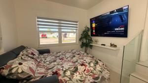 a bedroom with a bed and a flat screen tv at Comfortable modern apartment- central location. in Miami