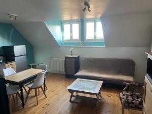 ein Wohnzimmer mit Sofa und Tisch in der Unterkunft Le studio 99 in Neuville-Saint-Rémy