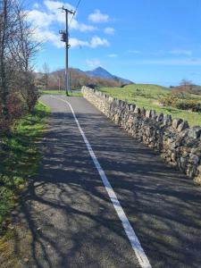 a road with a stone wall on the side at Reek View Accommodation in Westport
