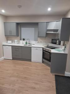 an empty kitchen with white appliances and wooden floors at Reek View Accommodation in Westport