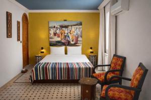 a bedroom with a bed and a painting on the wall at Le balcon de tanger in Tangier