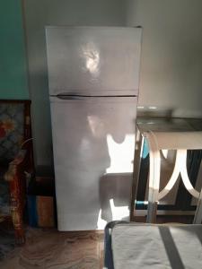 a refrigerator freezer sitting in a room next to a table at El Basha Apartment sea View in Dumyāţ al Jadīdah