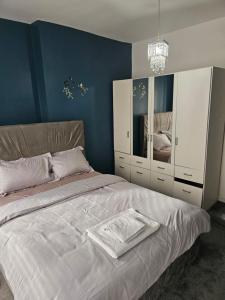a bedroom with a large bed with blue walls at M4 Victoria Hub in Newport