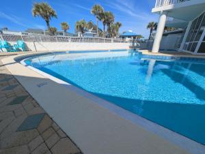 a swimming pool at a resort with blue water at Gulf Balcony - Boutique Comforts & 2 King Suites in Fort Walton Beach