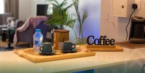 a counter top with two cups and a bottle of water at شاليه روجا Roja Chalet in As Sulayf