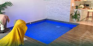 a swimming pool in a living room with a yellow and blue floor at شاليه روجا Roja Chalet in As Sulayf