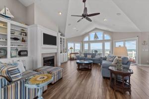 a living room with a couch and a fireplace at 4099 - 3-2-1 Relax in Duck