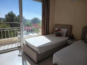 a bedroom with a bed and a balcony with a view at Karima house B in Al Aqālitah