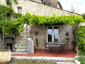 a stone house with a table and chairs on a patio at Le Logis - Maison authentique avec jardin et vue panoramique in Mons