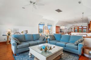 a living room with blue couches and a coffee table at 2437 - Sandpiper Station in Duck