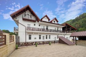 a large white house with a balcony at Residence Deluxe Benamino in Bran