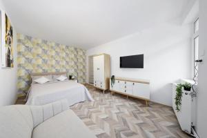 a bedroom with a bed and a tv on a wall at Residence Deluxe Benamino in Bran