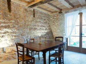 a dining room with a wooden table and chairs at Le Logis - Maison authentique avec jardin et vue panoramique in Mons