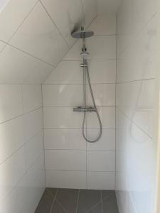 a white shower with a shower head in a bathroom at R&A Unterkunft in Oberhausen