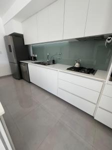 a white kitchen with a sink and a refrigerator at Casa Granadero Baigorria in Paganini