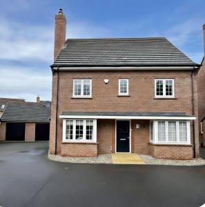 a brick house with white windows and a driveway at Your Versatile Luxury - Space for All- Sleeps 10 in Bedford
