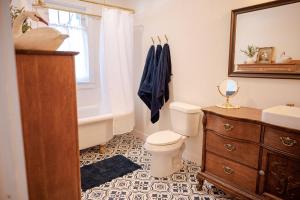 a bathroom with a toilet and a sink and a mirror at The Old Crowe Inn Bed and Breakfast in Fruita +9 photos