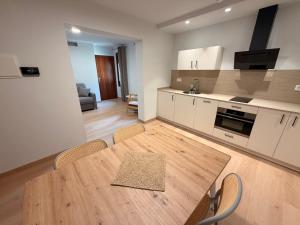 a kitchen and dining room with a wooden table and chairs at Apartamentos Ésera in Santa Liestra y San Quílez