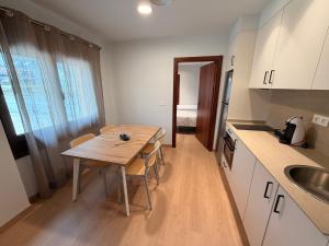 a small kitchen with a wooden table and a sink at Apartamentos Ésera in Santa Liestra y San Quílez