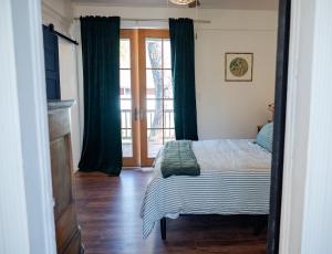a bedroom with a bed and a sliding glass door at The Old Crowe Inn Bed and Breakfast in Fruita