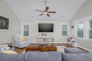 a living room with a couch and a tv at 5176 - Sandy Bottoms in Kill Devil Hills