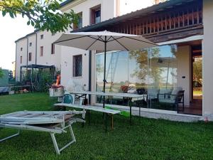 a patio with a table and an umbrella on the grass at Residenza Airone in Vicenza