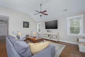 a living room with a blue couch and a tv at 5176 - Sandy Bottoms in Kill Devil Hills