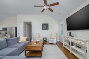 a living room with a couch and a flat screen tv at 5176 - Sandy Bottoms in Kill Devil Hills