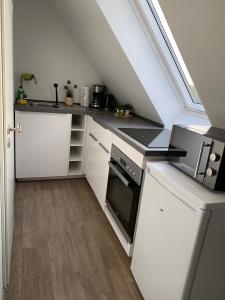 a kitchen with white cabinets and a black counter top at R&A Unterkunft in Oberhausen
