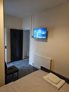 a bedroom with a bed and a flat screen tv on the wall at M4 Victoria Hub in Newport