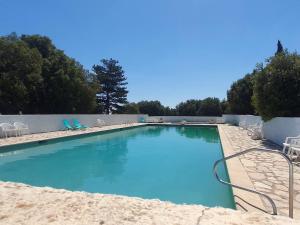 a large swimming pool with blue water and chairs at Le Logis - Maison authentique avec jardin et vue panoramique in Mons