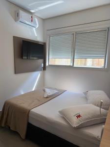 a bedroom with a large bed with two windows at Hotel Morais in Lagoa Vermelha