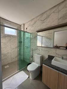 a bathroom with a toilet and a shower and a sink at Hotel Morais in Lagoa Vermelha