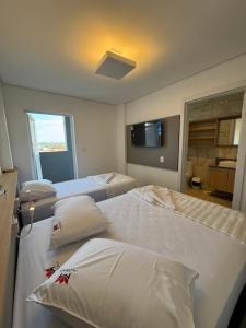 a hotel room with two beds and a television at Hotel Morais in Lagoa Vermelha