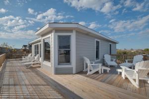 a deck with white chairs and a tiny house at 3941 - Fleur de Duck in Duck
