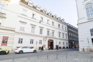a white car parked in front of a large building at Beethoven Suite in Vienna