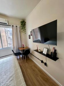 a living room with a large flat screen tv on the wall at Apto no Centro de Porto Alegre in Porto Alegre
