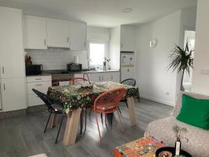 a kitchen and dining room with a table and chairs at Relaxing Cabin Next to the River - La Cabaña de Susana in Negreira