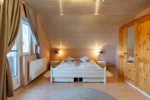 a bedroom with a white bed in a room at Lagom Vendégház in Zalaszentgrót
