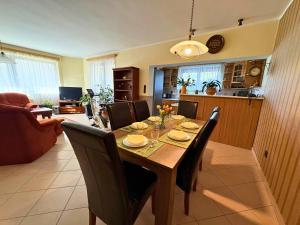 a dining table and chairs in a living room at Rigódal Vendégház in Eger