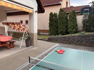 a ping pong table in the backyard of a house at Rigódal Vendégház in Eger