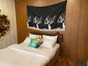 a bed with white pillows and a painting on the wall at Acacia Homes in Kuldanna