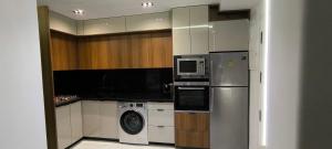 a kitchen with a refrigerator and a washing machine at Magnifique appartement de trois chambres, Résidence Kabila Vista in M'diq