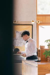 a man in a white shirt and a bow tie at AUBERGE FRANKENBOURG in La Vancelle