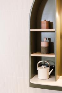 a shelf with a white tea kettle on it at AUBERGE FRANKENBOURG in La Vancelle
