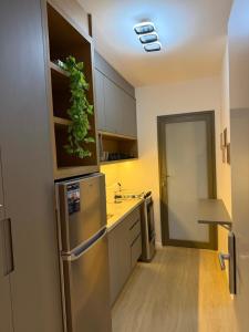 a kitchen with a stainless steel refrigerator with a plant on it at Maison Perdizes 506 - Até 6 pessoas - Allianz Parque in São Paulo