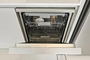 a dishwasher with its door open in a kitchen at Warm and Cozy 4BR Villa with Pool Access in Dubai +71 photos