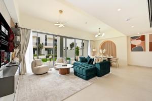 a living room with a green couch and chairs at Warm and Cozy 4BR Villa with Pool Access in Dubai