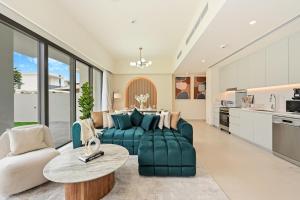 a living room with a green couch and a table at Warm and Cozy 4BR Villa with Pool Access in Dubai