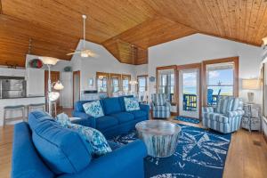 a living room with blue couches and a wooden ceiling at 2410 - Come Sail Away in Duck